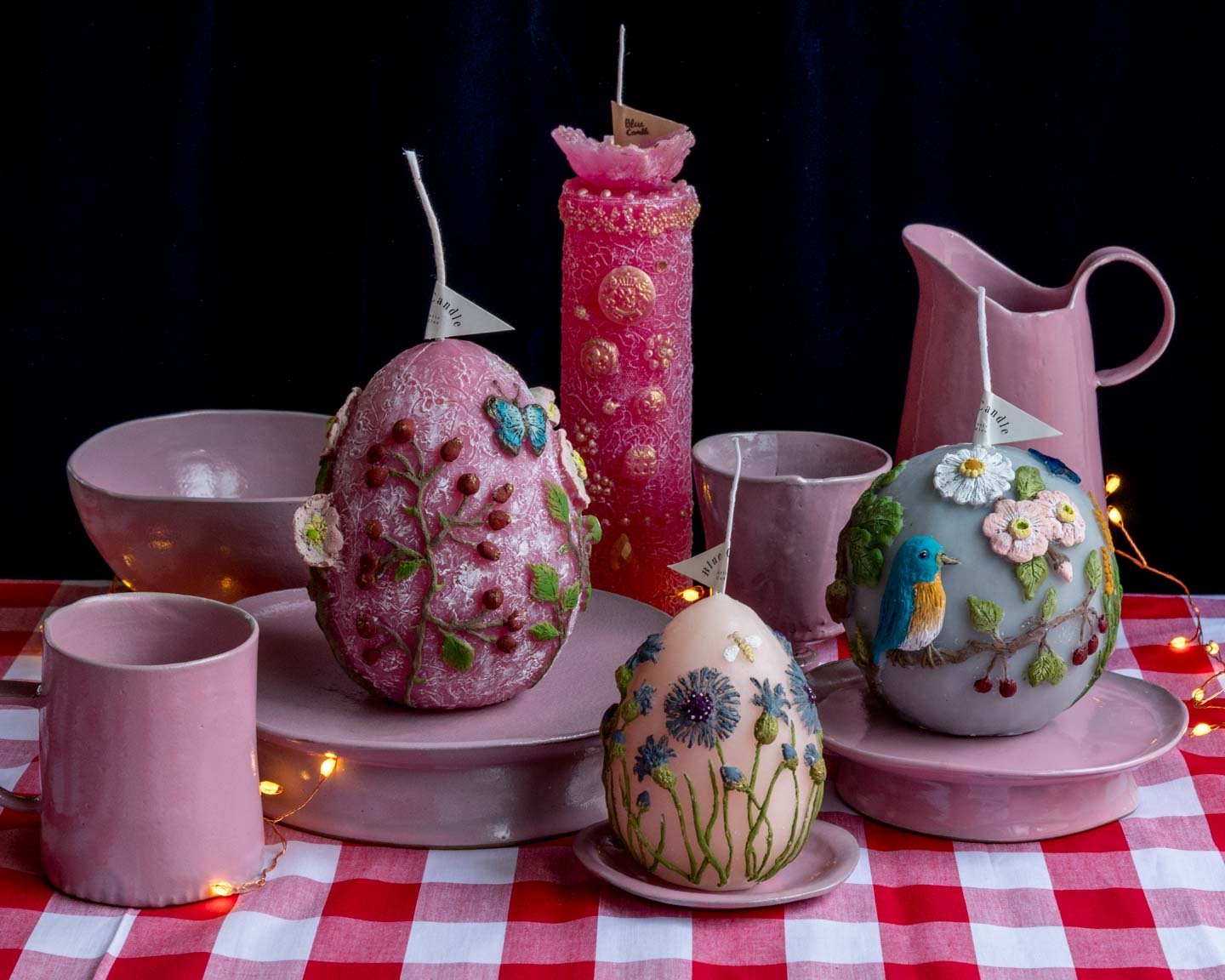 Blue Candleさんの花や鳥をまとったキャンドルとteto ceramicsさんのピンクのうつわを並べたCARNIVALのテーブル